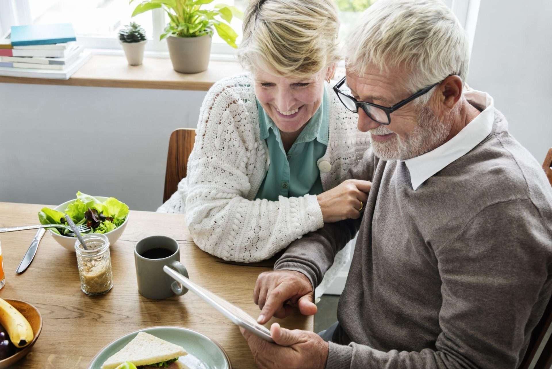 Elderly couple smiling sitting at dinner table