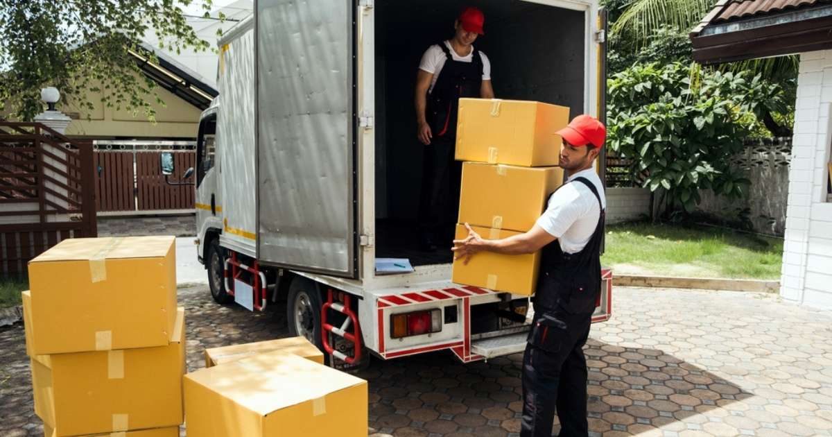 Two movers from a moving company in Oatfield, OR handling boxes from a truck