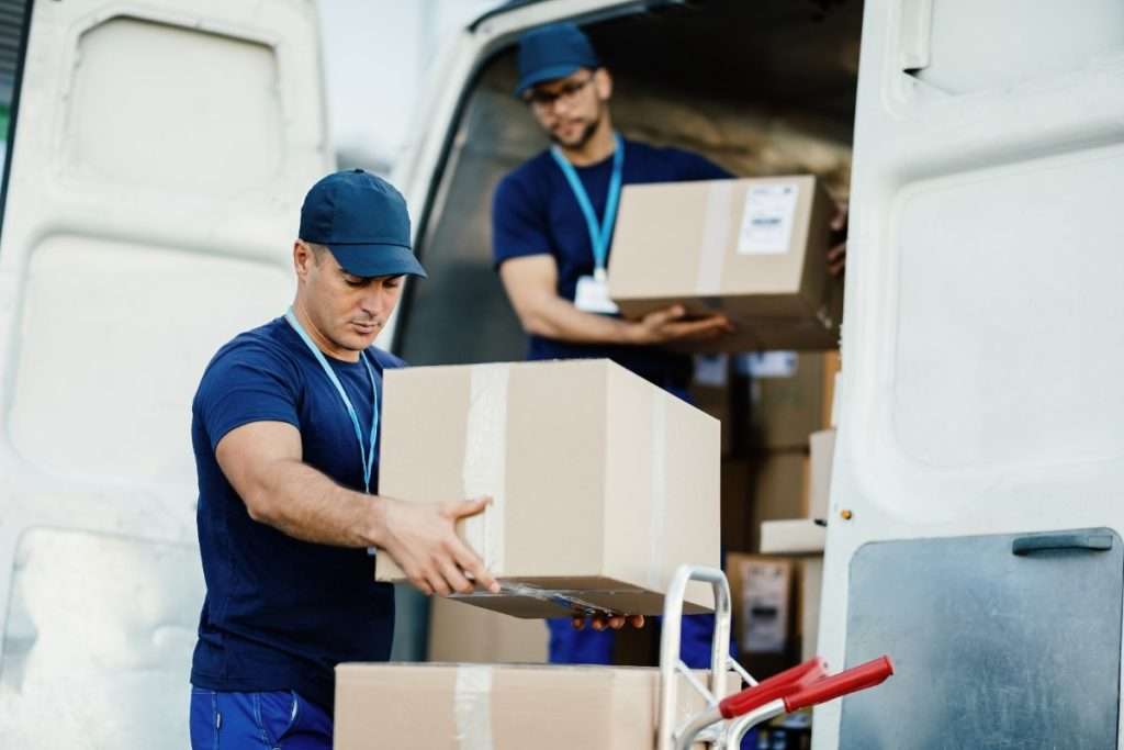 Cumings movers in blue T-shirts stacking boxes on a handtruck