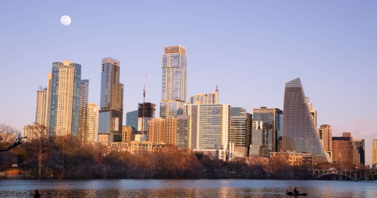 The skyline of Downtown Austin during sunset, with the moon in the sky