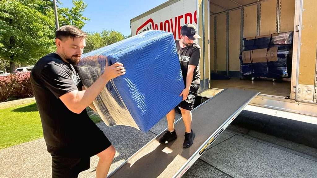 Two Hillsboro professional movers loading furniture into a moving truck