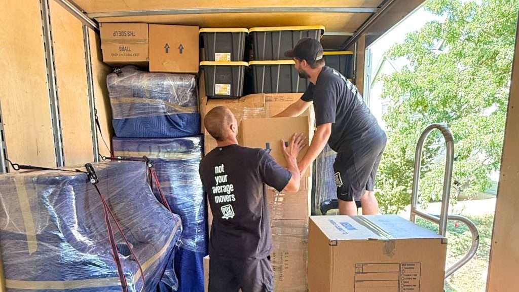 Two professional movers organizing the inside of a moving truck during a Hillsboro move