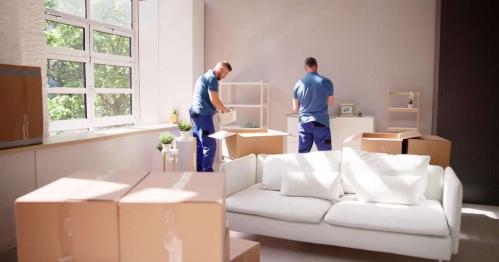 Two movers in Memorial TX packing furniture and household goods into boxes