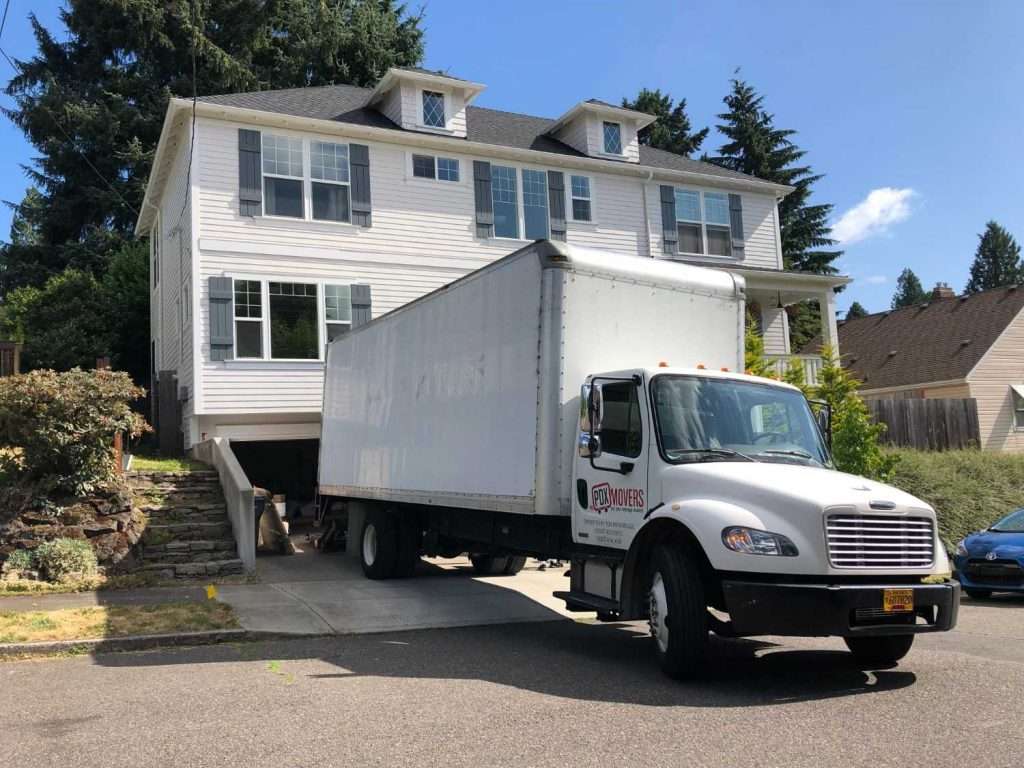 PDX Movers moving truck parked in residential driveway